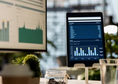 Ekrany monitora i tabletu przedstawiające wykresy do efektywnego zarządzania firmą