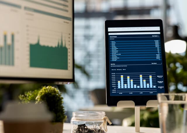 Ekrany monitora i tabletu przedstawiające wykresy do efektywnego zarządzania firmą